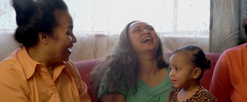 Islander family laughing and smiling at toddler