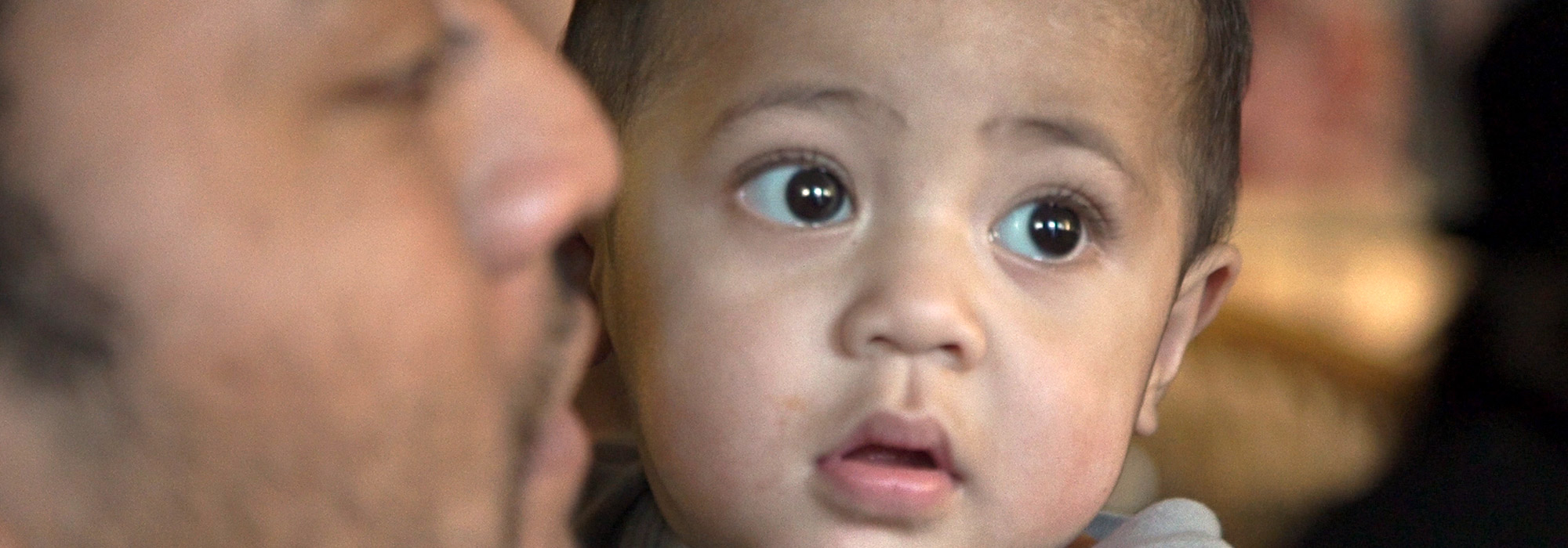 Islander father kissing baby